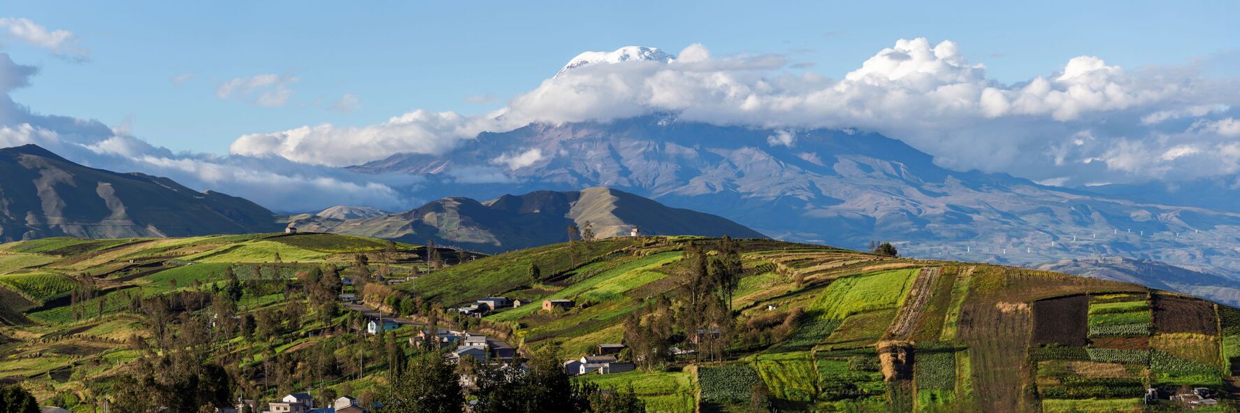 Snow-capped Chimborazo Volcano above Ecuadorian highlands with scattered clouds