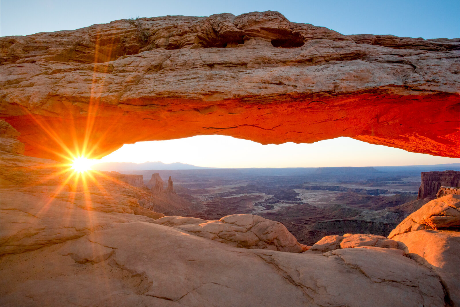 Mesa Arch framing sunburst and canyon view in Canyonlands National Park